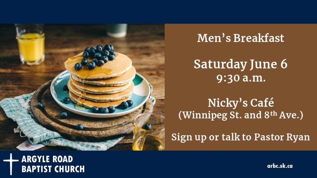 pancakes topped with blueberries on a plate with a glass of orange juice