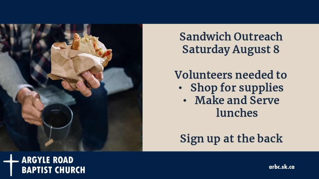 a man eating a sandwich from a brown bag and holding a cup of tea.